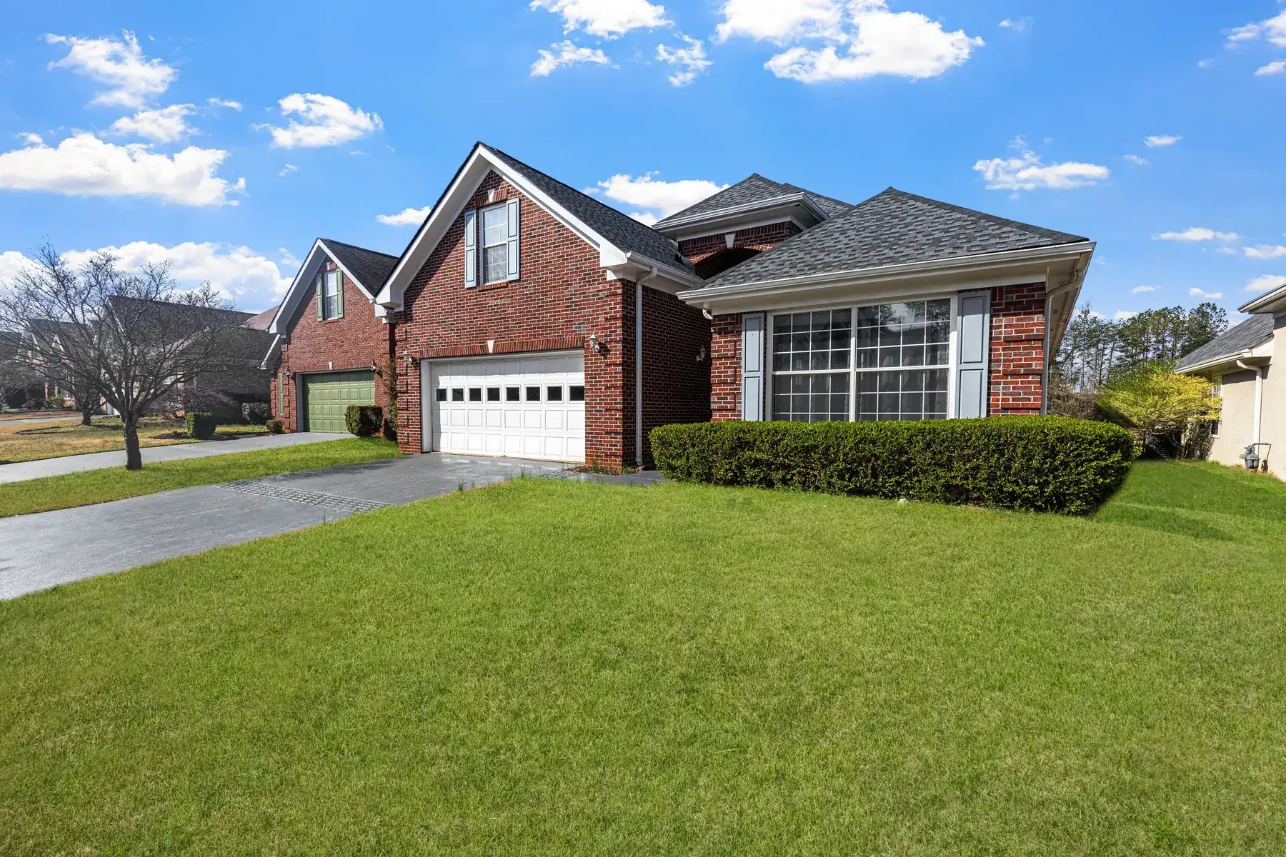Freshly mowed front lawn and trimmed hedges at a brick home
